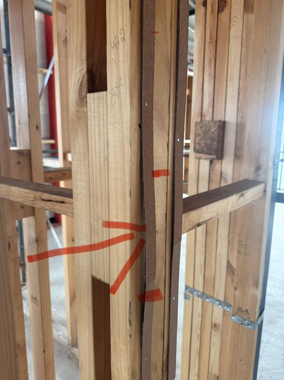 Wall framing and junction detail marked during a pre-plaster inspection.